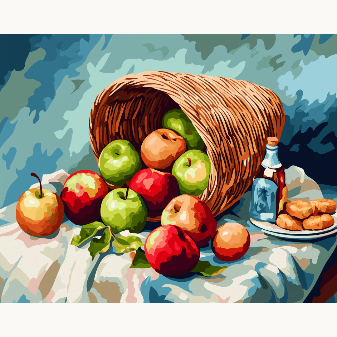 A wicker basket filled with ripe apples sits on a blue surface, surrounded by a few whole apples and an empty bottle nearby..